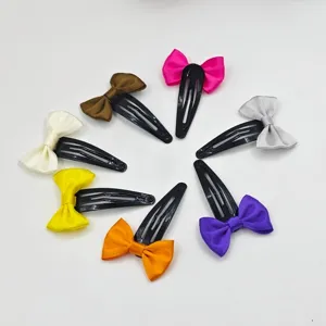Colorful ribbon bow hair clips detail view, showing multi-color fabric bows on metal BB clips.