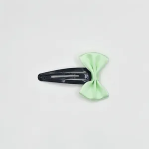 Detailed shot of a sweet ribbon bow girl BB hair clip in light green, cute daily accessory.