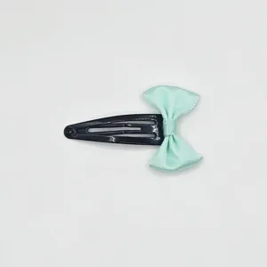 Detail view of a cute mint green ribbon bow snap hair clip, sweet girl hair accessory.