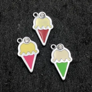 Gros plan de pendentifs crème glacée en émail coloré avec détails strass pour la bijouterie.