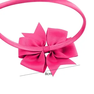 Close-up detail of a bright pink children's hair hoop featuring an 8cm grosgrain bow.