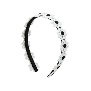 Detailed shot of sweet white daisy lace headband on black band, stylish accessory for girls.