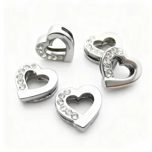 Primo piano di ciondoli a cuore in strass argentati, perfetti per bracciali e collane DIY.