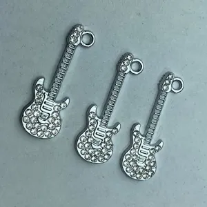 Detailaufnahme von silbernen Strass-Gitarrenanhängern, glänzende Kristall-DIY-Zubehörteile.