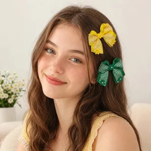 Charming detail shot showing plaid hair bows with pearls and flowers worn by a smiling girl.