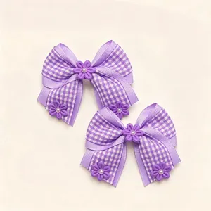 Purple checkered ribbon bow detail shot, showing delicate fabric flower and pearl accents clearly.