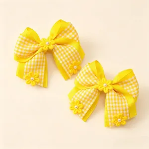 Detail view of yellow checkered hair clips featuring cute fabric bows, flowers, and pearl accents.