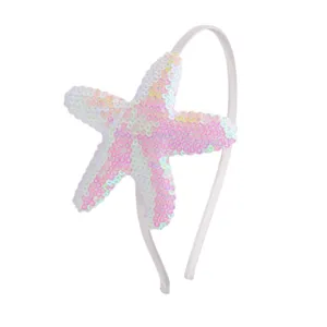 Primer plano del detalle de diadema de estrella de mar con lentejuelas, accesorio rosa.