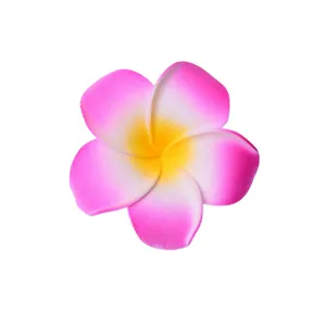 Vista di dettaglio di fiore frangipani artificiale, petali rosa e gialli primo piano.