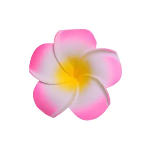 Primo piano dettagliato del vivace accessorio per capelli con fiore di frangipani artificiale rosa.