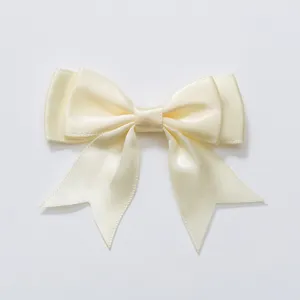 Gedetailleerde close-up van de elegante beige dubbellaagse strik haarspeld en accessoire.