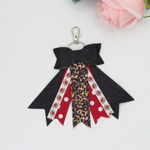 Cute cheer bow keychain with football and leopard print ribbons, perfect stylish bag charm accessory.