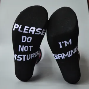 Detail view of black casual cotton mid-calf socks featuring novelty white text jacquard.