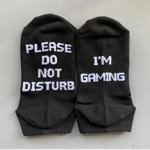 Close-up detail of black cotton casual socks featuring funny knitted white letter text design.