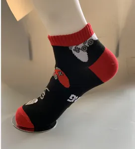 Close-up detail of black cotton casual socks featuring retro gaming controller patterns.