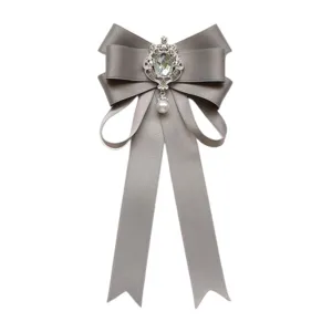 Elegante graue Schleifen-Brosche mit Strassstein-Mitte und Perlenanhänger für Damen.