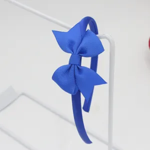 Vue détaillée d'un serre-tête nœud ruban gros-grain bleu roi vibrant sur support.