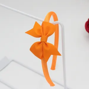 Détail de serre-tête nœud ruban gros-grain orange, accessoire élégant femmes et filles.