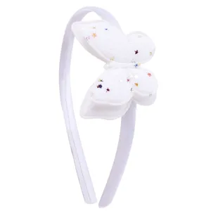 Gros plan détaillé du serre-tête papillon en tissu blanc avec étoiles scintillantes et douces.