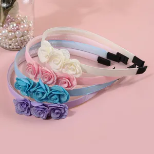 Nahaufnahme von bunten Stoffblumen Haarreifen mit süßem Blumendesign und Zähnen.