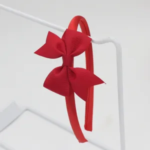 Serre-tête rouge avec nœud en ruban grosgrain vue détaillée montrant le joli design texturé.