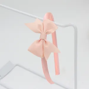 Détail de serre-tête nœud ruban rose, design minimaliste mignon pour coiffure quotidienne.