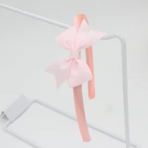 Serre-tête en satin rose avec un nœud en gros-grain chic, accessoire élégant quotidien.