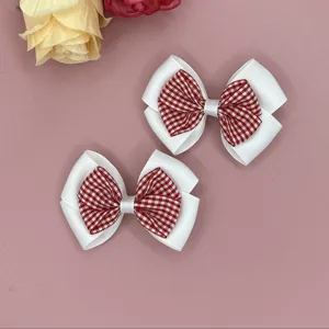Detailed close-up of cute red gingham and white ribbon bow hair clips for sweet daily styling.
