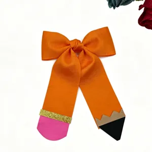 Close-up detail of a creative pencil shaped hair bow accessory, featuring vibrant orange ribbon.