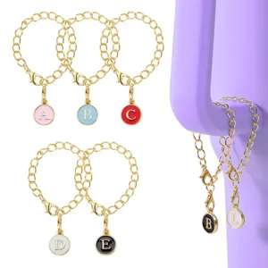 Détail de bracelet en chaîne alliage doré avec pendentifs lettres émaillées rondes doubles.