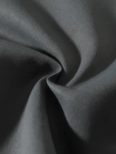 Gros plan sur la texture du tissu tissé gris foncé, montrant une qualité supérieure et douce.
