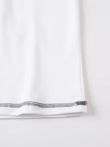 White cotton polo shirt hem detail showing contrast stitching for comfortable summer wear.