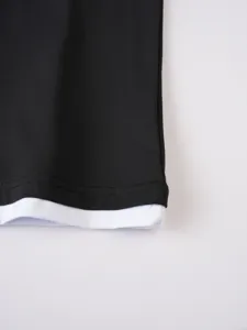 Λεπτομέρεια στριφώματος ανδρικού t-shirt, ασπρόμαυρο σχέδιο στρώσεων, casual.