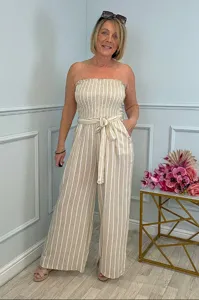 Detailed view of a stylish strapless striped jumpsuit featuring a belted waist and wide legs.