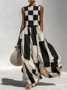 Close-up detail shot of a black and white geometric sleeveless maxi dress in a scenic outdoor setting.
