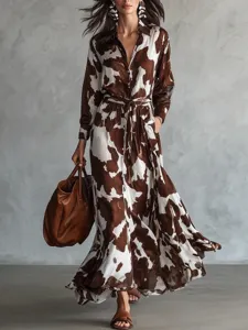 Brown and white cow print long sleeve shirt dress for women with tie and flared hemline.