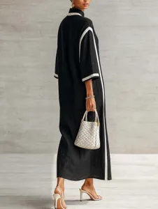 Elegant black long dress with white contrast piping, stand collar, and chic minimalist style.
