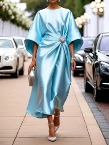 Elegant satin midi dress featuring crystal brooch detail, perfect for chic commuting looks.
