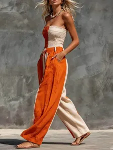 Details of the strapless color-block cotton linen jumpsuit showing orange and beige panels.