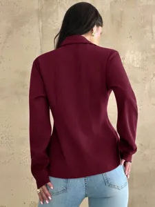 Detailed back view of a stylish burgundy slim-fit blazer jacket paired with casual denim jeans.