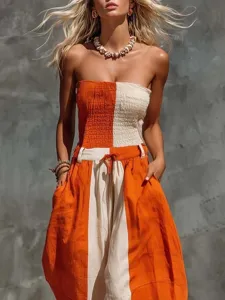 Detail view of a fashionable strapless orange and off-white color-blocked cotton linen jumpsuit.