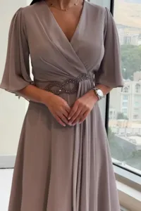 Elegant V-neck pleated maxi dress with beaded waist detail, perfect for chic evening wear.