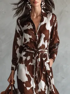 Brown and white cow print long sleeve shirt dress featuring a chic cinched waist and maxi skirt.