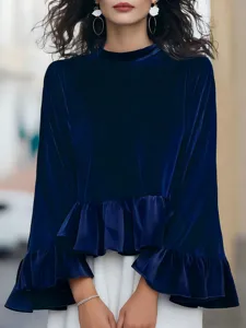 Detail view of a navy velvet long-sleeve top with elegant ruffled hem and classic crew neck.