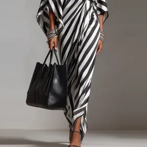 Detail view of stylish black and white striped dress paired with elegant tote bag and bracelets.