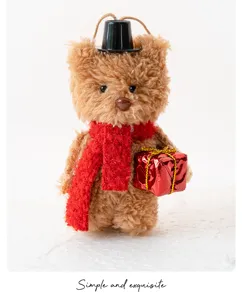 Gros plan d'un charmant ornement d'ours en peluche avec haut de forme et écharpe rouge.