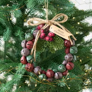 Christmas jingle bell wreath hanging ornament with pine cones and rustic burlap bow decor.