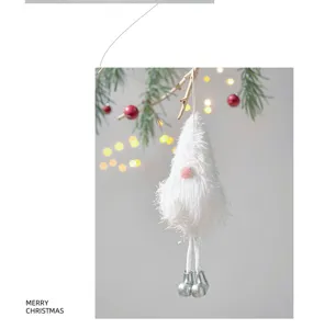 Weißer Plüsch Weihnachtswichtel Anhänger Detail am Tannenzweig mit Festtagsbeleuchtung.