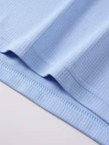 Hellblaue Waffelstrick Texturdetails der Sportweste, atmungsaktives schnelltrocknendes Material.