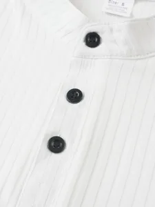Détail de débardeur sans manches côtelé blanc pour homme, avec boutons noirs et col.